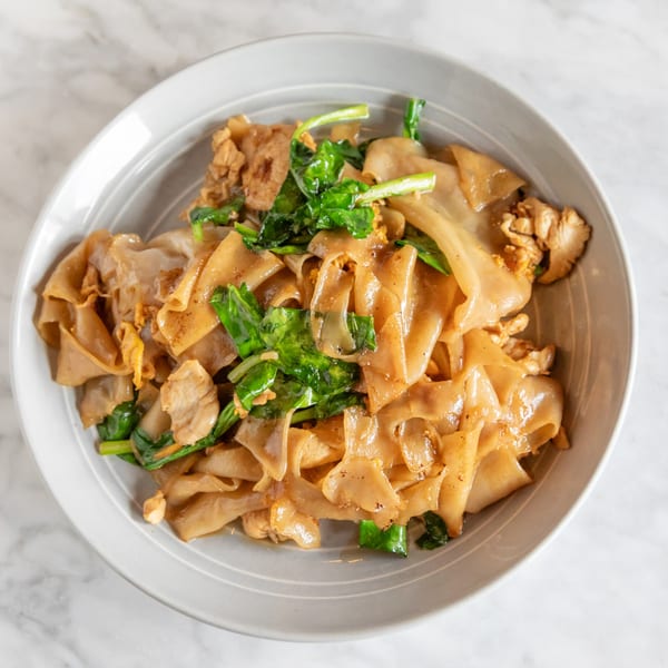 Phattra Thai Restaurant's Pad See Ew with wide noodles, chicken, and green vegetables in a white bowl.