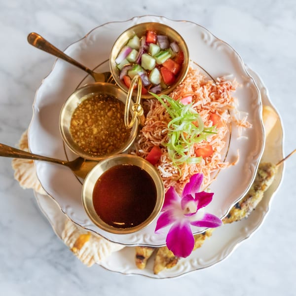 Phattra Thai appetizer platter with crispy noodles, sauces, and a purple orchid garnish.