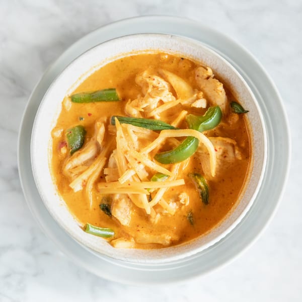 Phattra Thai red curry with chicken, bamboo shoots, and green bell peppers in a white bowl.